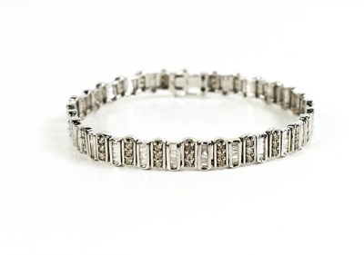 Lot 14 - A 9ct white gold and diamond tennis bracelet,...