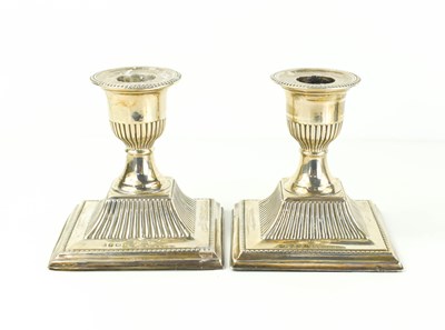 Lot 382 - A pair of silver candlesticks, of short form,...