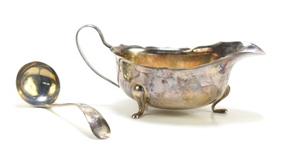 Lot 384 - A silver sauce boat with scalloped rim and...