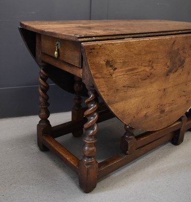 Lot 475 - A 18th century oak drop leaf table, the oval...