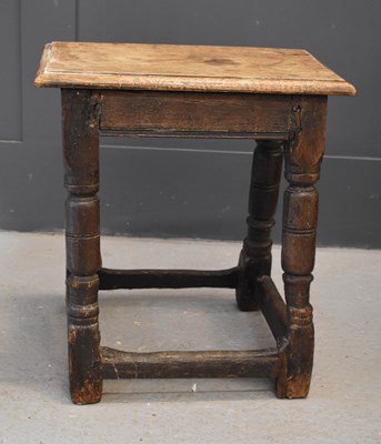 Lot 462 - A 17th century oak joint stool, the slab top...