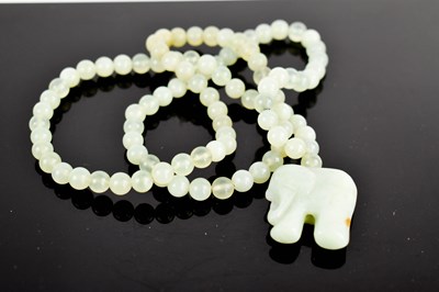 Lot 36 - A pale jade bead necklace, with elephant...