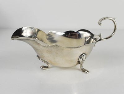 Lot 144 - A silver sauce boat, with shaped edge, and...