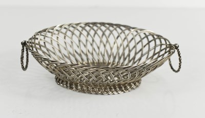 Lot 426 - A white metal basket form dish with twin hoop...