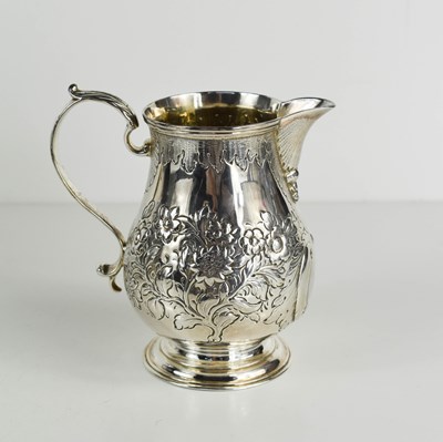 Lot 468 - A Georgian silver jug, embossed with flowers...