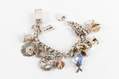 Lot 234 - A silver charm bracelet, the curb link chain...