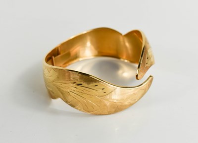 Lot 3 - An 18ct gold bangle, engraved with foliage and...