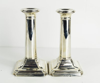 Lot 400 - A pair of silver column form candlesticks,...