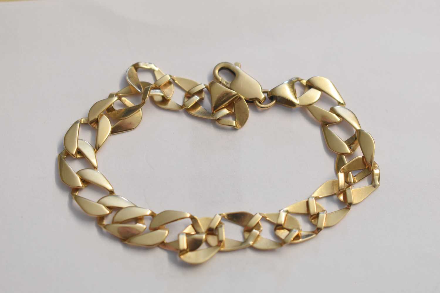 Lot 108 - A 9ct gold flat curb link bracelet, 8.1g.