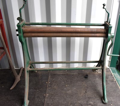 Lot 345 - A vintage sheet metal roller on a cast iron...