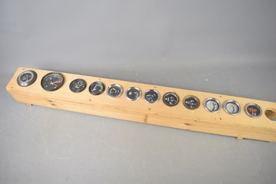 Lot 20 - A collection of vintage car dials mounted on a...