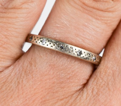 Lot 65 - A 9ct white gold and diamond eternity ring,...