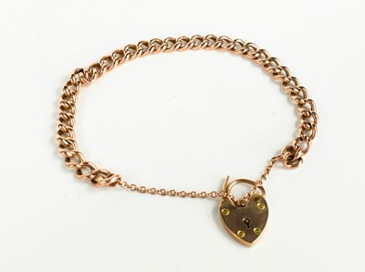 Lot 149 - A 9ct gold curb link charm bracelet with heart...