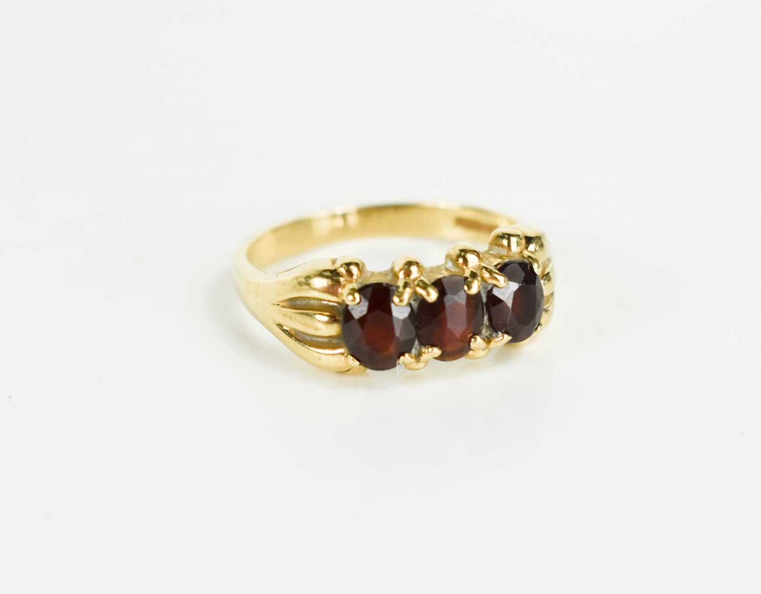 Lot 60 - A 9ct gold and garnet three stone ring, size L,...