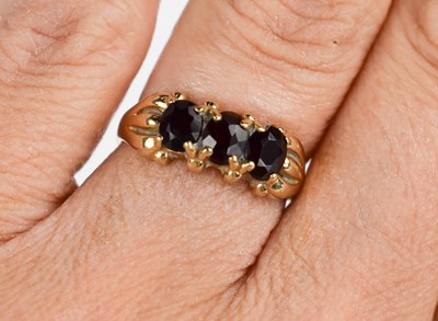 Lot 60 - A 9ct gold and garnet three stone ring, size L,...