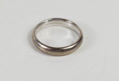 Lot 205 - An 18ct white gold wedding band of curved form,...