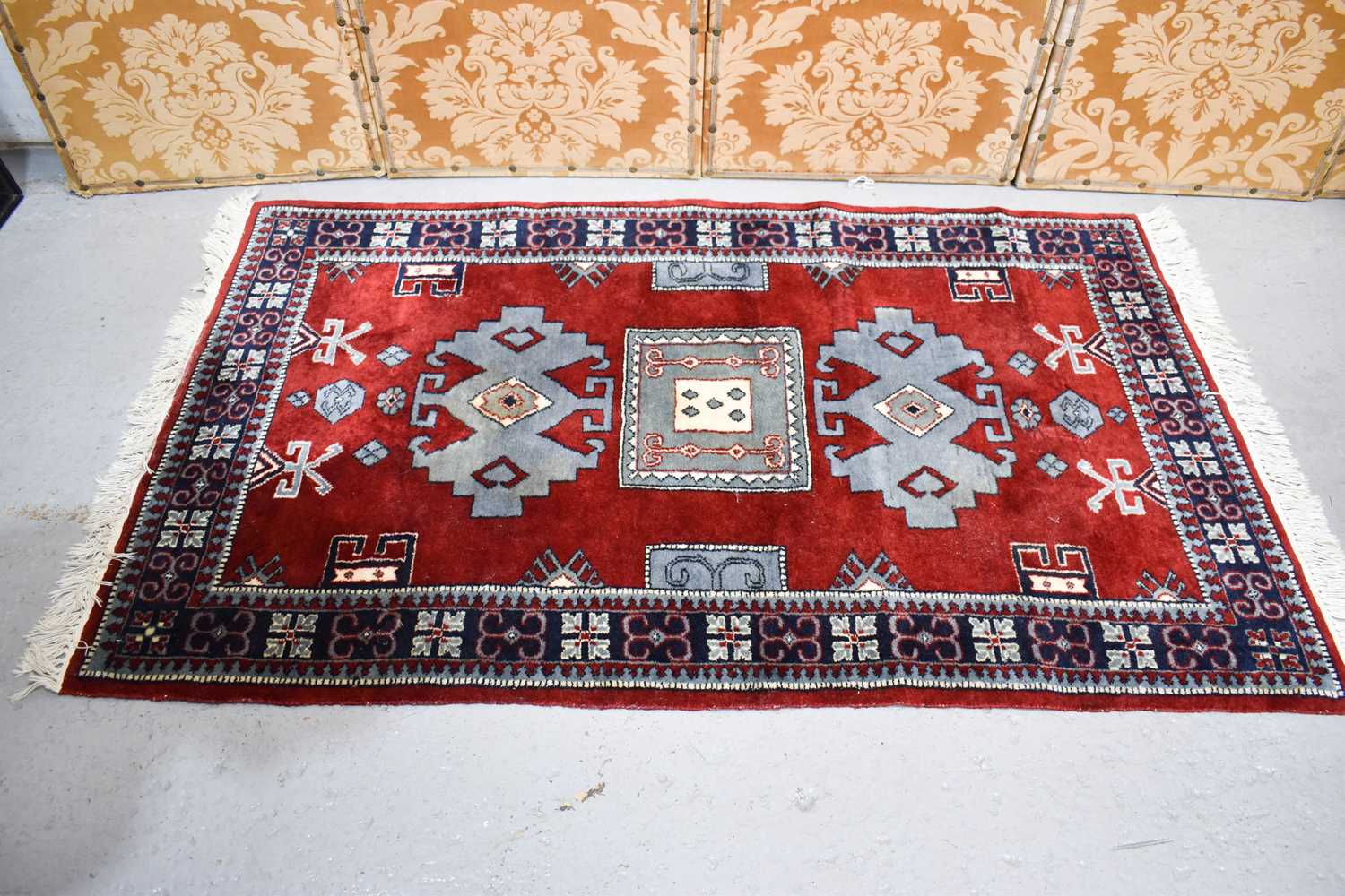 Lot 582 - A Middle Eastern rug with a red ground, blue...