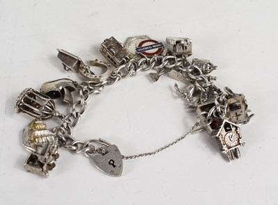 Lot 76 - A silver curb link charm bracelet, with...