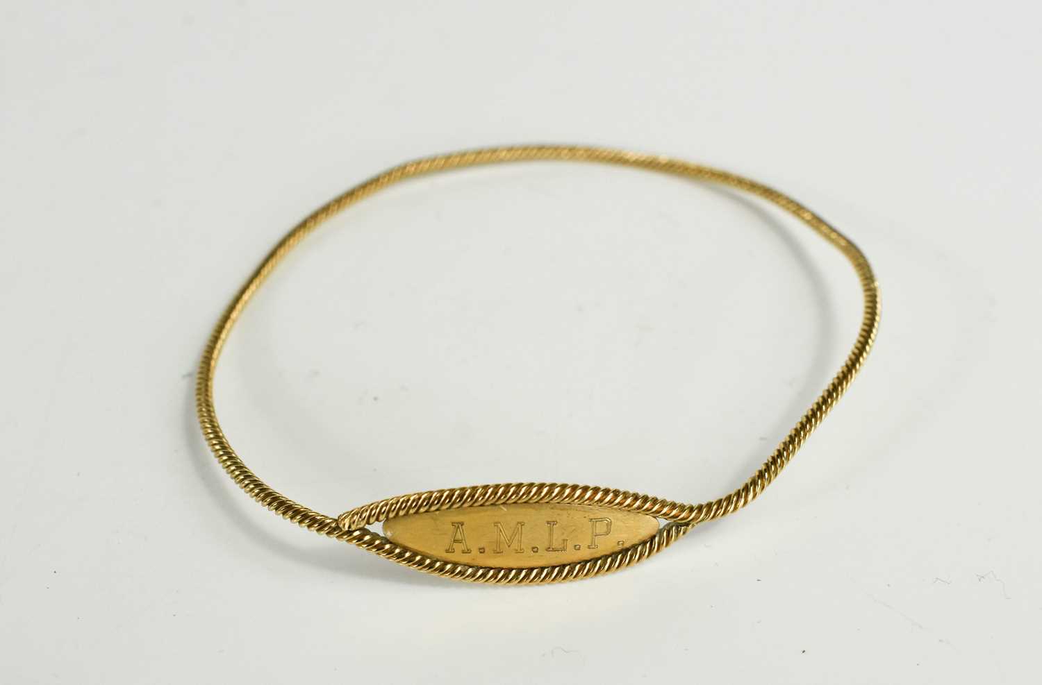 Lot 77 - A 9ct gold name bangle, with twist detail,...