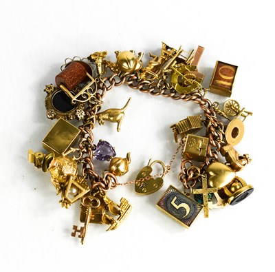 Lot 82 - A 9ct gold charm bracelet, with thirty six...