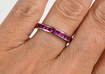 Lot 16 - A 14ct white gold and ruby half eternity ring,...