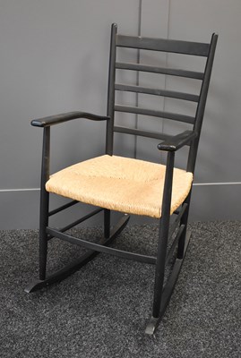 Lot 153 - A Danish black wooden and wicker seat rocking...