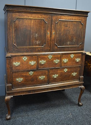 Lot 563 - A Georgian oak cabinet on chest raised on...