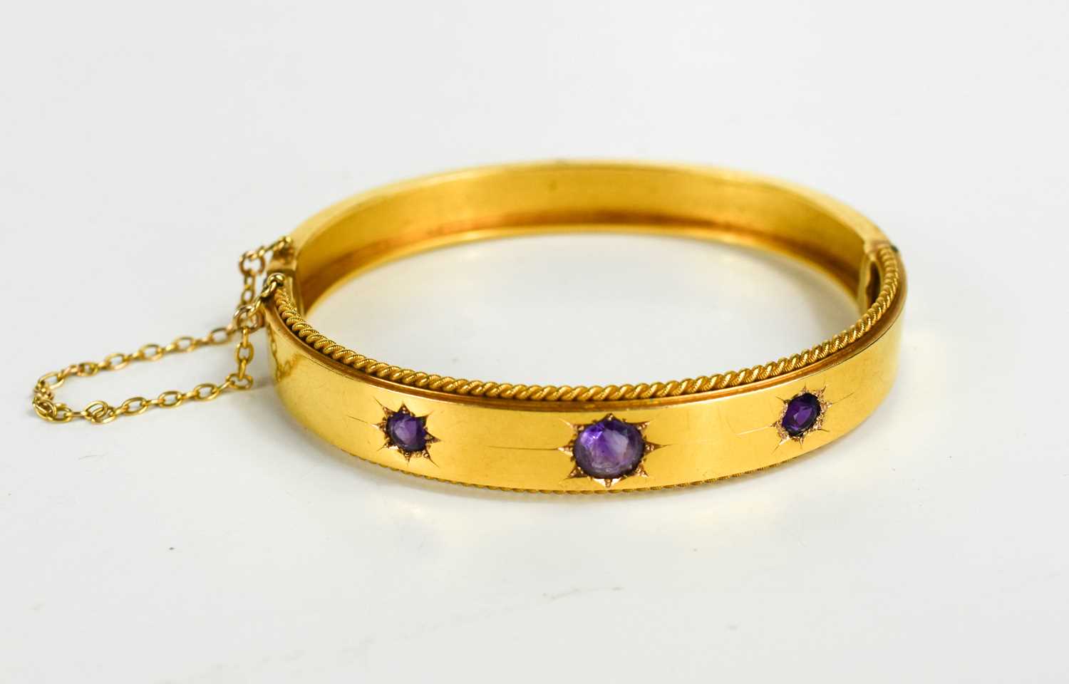 Lot 35 - A Victorian 15ct gold and amethyst set bangle,...