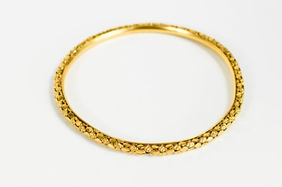 Lot 245 - A gold bangle of florette and lozenge form,...