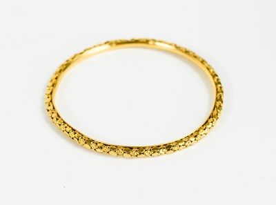 Lot 244 - A gold bangle of florette and lozenge form,...