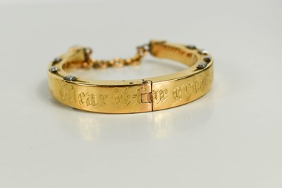 Lot 39 - A gold horse shoe form bangle, engraved 'Wear...