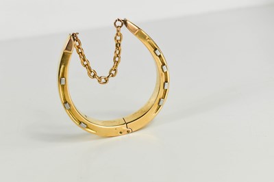 Lot 39 - A gold horse shoe form bangle, engraved 'Wear...