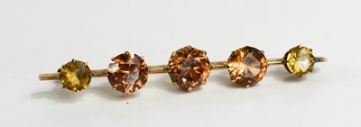 Lot 12 - A pale peach paste and citrine bar brooch, the...