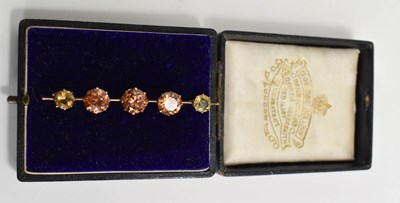 Lot 12 - A pale peach paste and citrine bar brooch, the...