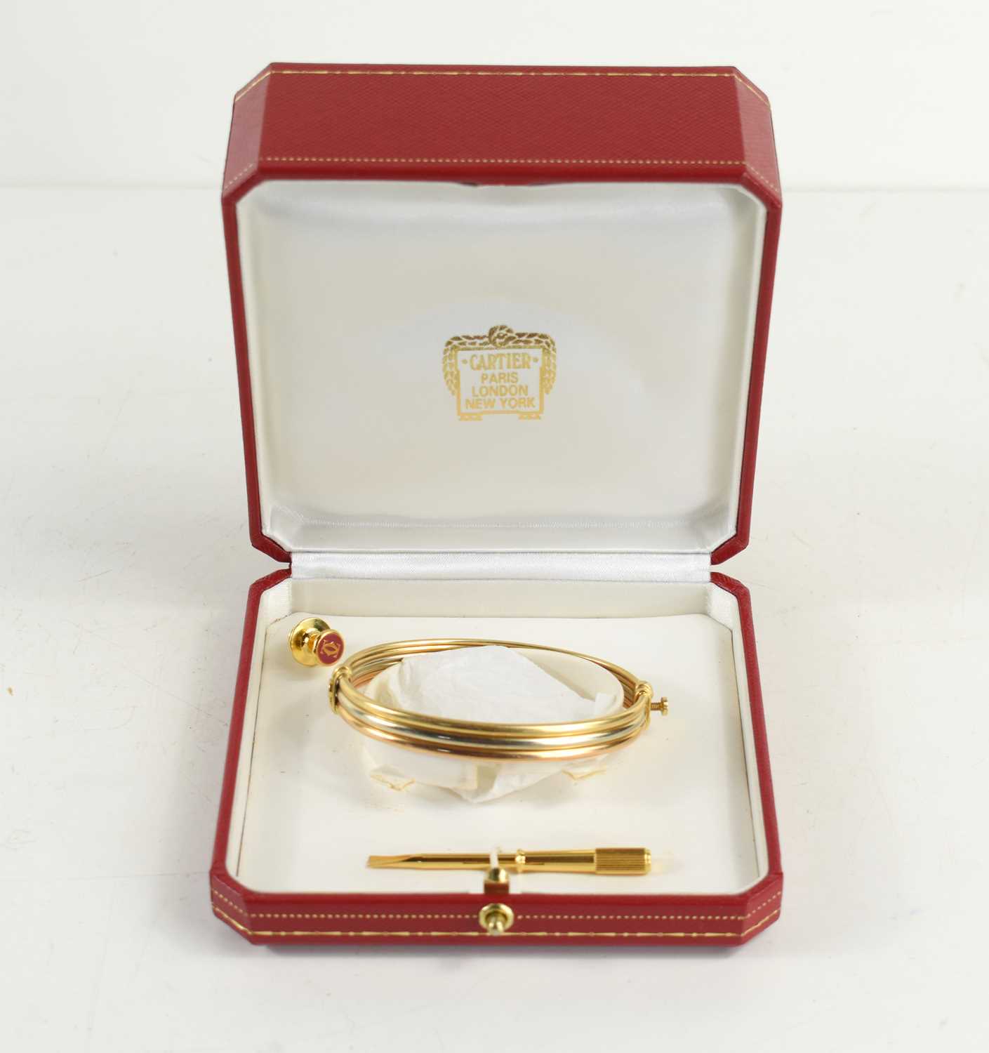 Lot 55 - A Cartier 18ct three tone gold bangle, the...