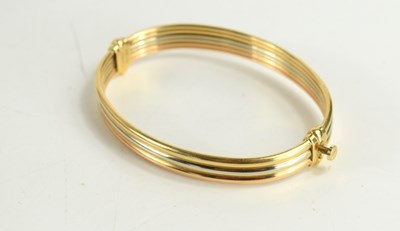 Lot 55 - A Cartier 18ct three tone gold bangle, the...
