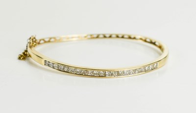 Lot 134 - A diamond and 9ct gold bangle, set with twenty...