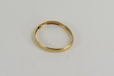 Lot 65 - A 9ct gold bangle with repousee finish, with...