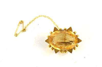 Lot 51 - A gold (unmarked) and citrine brooch, the oval...