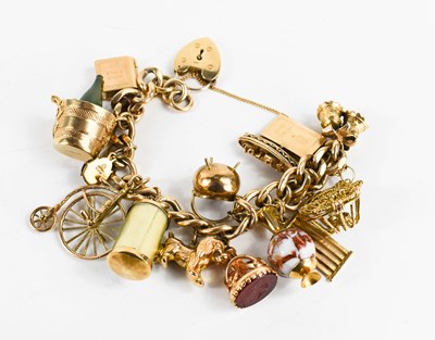 Lot 24 - A 9ct gold charm bracelet, with fourteen...