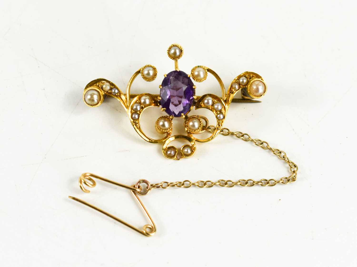 Lot 88 - A gold, amethyst and seed pearl brooch, with...