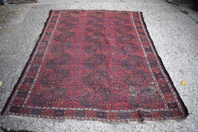 Lot 411 - A Middle Eastern red ground rug, with stylised...