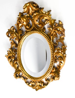 Lot 396 - A 20th century carved giltwood oval mirror,...