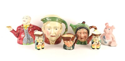 Lot 185 - A group of character jugs and teapots to...