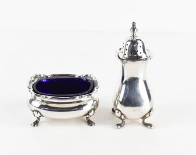 Lot 305 - A silver salt with blue glass liner, raised on...