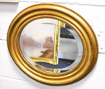 Lot 433 - An antique giltwood oval mirror with bevelled...