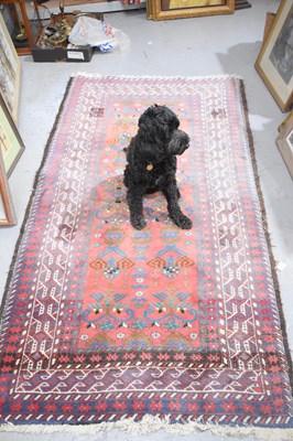 Lot 410 - A Middle eastern red ground rug with stylised...