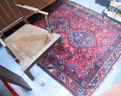 Lot 416 - A Middle Eastern rug with deep red ground...