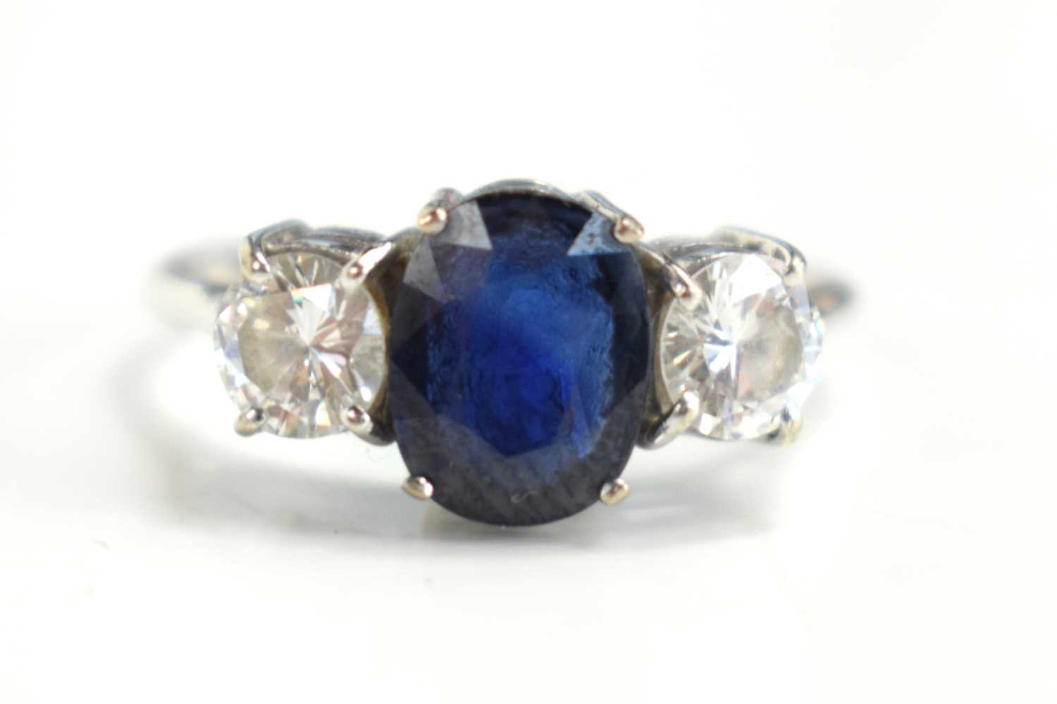 Lot 19 - An 18ct white gold, diamond and sapphire three...