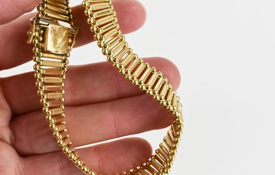 Lot 46 - A 14ct gold bracelet of alternating engraved...